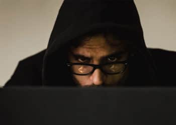 Hacker con logo de ethereum reflejado en los lentes.