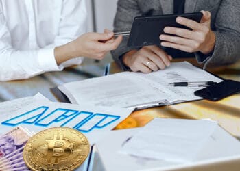Contadores, logo del AFIP, pesos argentinos y bitcoin.