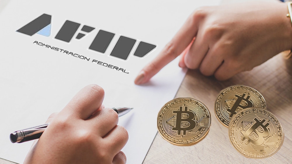 Planilla de AFIP y bitcoins sobre la mesa.