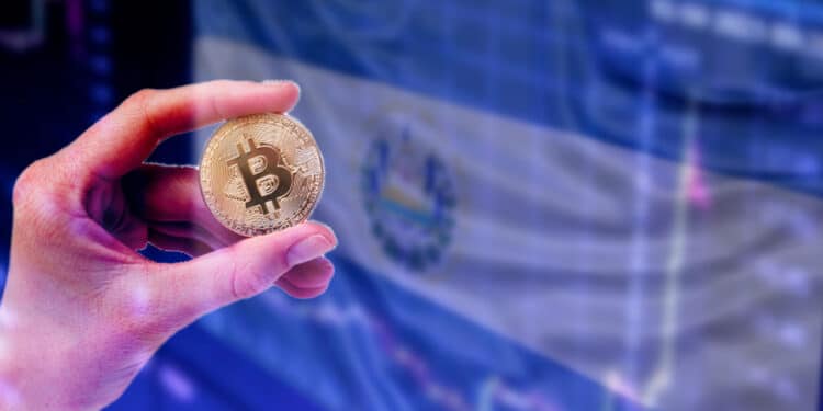 Pantalla con bandera de El Salvador y mano con bitcoin.