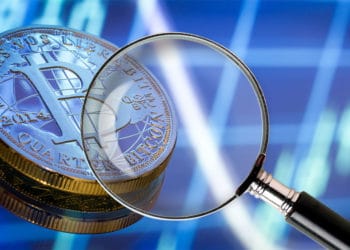 Bitcoin en fondo azul con lupa.