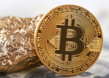 Bitcoin al lado de un trozo de oro.