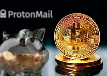 Bitcoins y alcancía de ahorro con logo de Proton Mail.