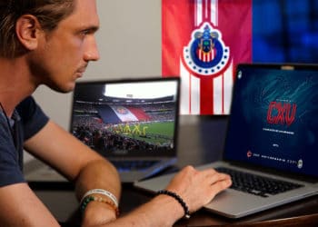 Persona comprando NFT de Chivas mientras ve un partido.