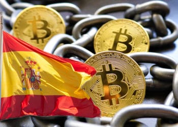 Bitcoin con cadenas que representran blochchain y bandera de España.