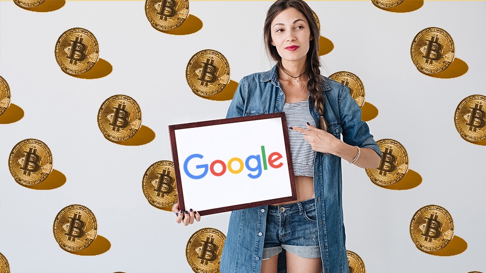 Persona sosteniendo cartel de Google con bitcoins en de fondo.