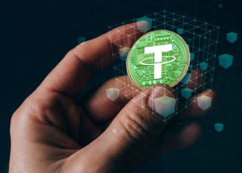 Mano sosteniendo Tether con blochain de fondo.