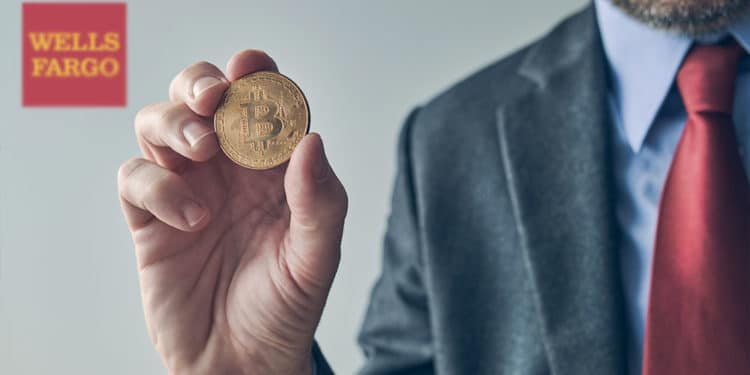Hombre de negocios con bitcoin en mano y logo de Wells Fargo al fondo.