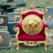 Bitcoin en silla real sobre cementerio de altcoins.