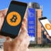 Sede de la Comisión europea y teléfonos con logo de bitcoin.