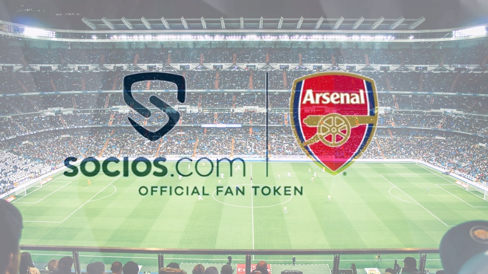 Campo de fútbol con logos de Arsenal y socios.com.