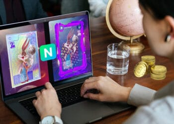 Persona con bitcoins sobre la mesa mirando NFT de Space Jam en NIfty's.
