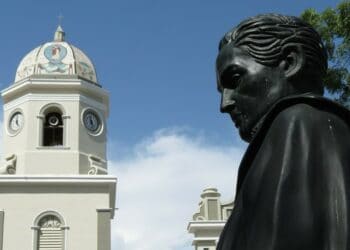 Busto de Simón Bolívar con campanario detrás.