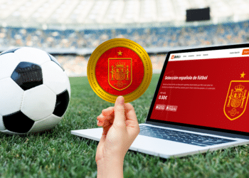 Campo de fútbol y balón con fan token de la selección de españa y su pantalla en Bitci.com.