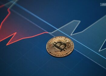 Moneda de bitcoin sobre grafica de precio