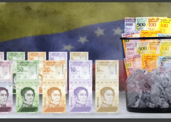 Papelera con bolívares viejos, nuevo cono monetario y bandera Venezuela.