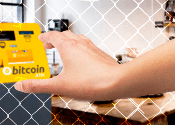 BTC ATM y mano entrando por reja.