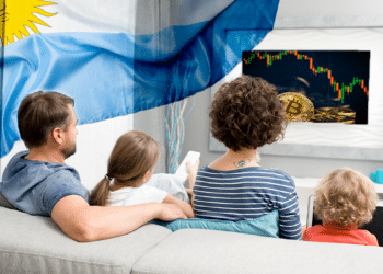 Familia viendo BTC en televisión con bandera de Argentina en el ambiente.