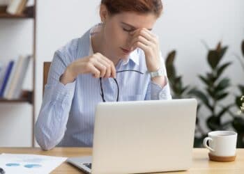 Mujer pensativa frente a una laptop