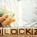 Logo de Blockzy en cubos de madera con hombre entregando billetes de euro con logo de Bitinka en camisa. Composición por CriptoNoticias. BitInka / bitinka.com; Blockzy / blockzy.com; twenty20photos / elements.envato.com.