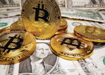 Monedas de bitcoin sobre billetes de USD dólares