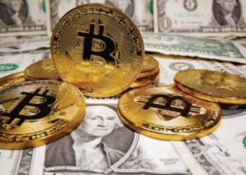 Monedas de bitcoin y billetes de dólares sobre una mesa