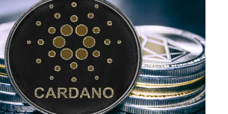 Moneda de Cardano recostada en dos pilas de criptomonedas