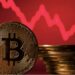 Pila de monedas de bitcoin frente a gráfico de precios en rojo