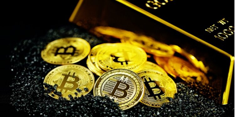 Monedas de bitcoin sobre fragmentos de carbón y al lado de un lingote