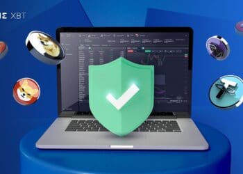 Computadora portátil abierta con criptomonedas flotando alrededor.