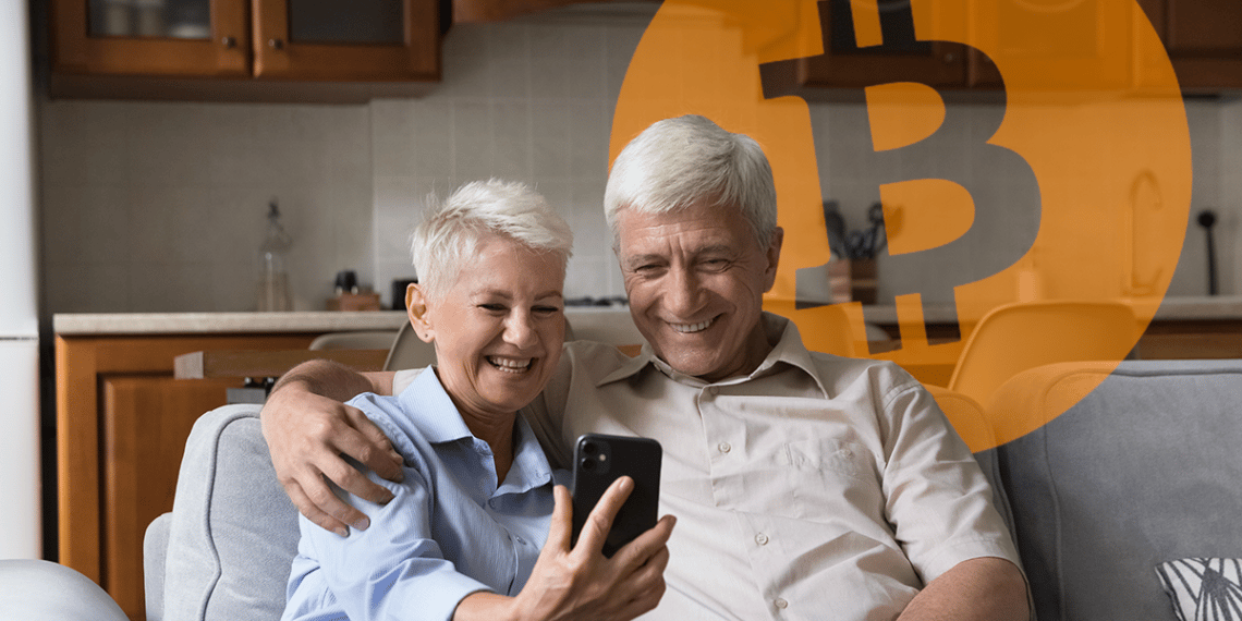 Adultos mayores mirando el celular con un bitcoin de fondo.