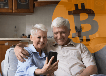 Adultos mayores mirando el celular con un bitcoin de fondo.