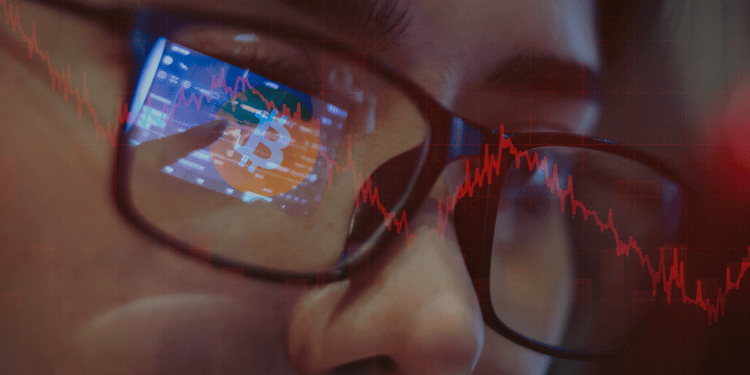 Persona observando análisis de precio de Bitcoin en rojo.