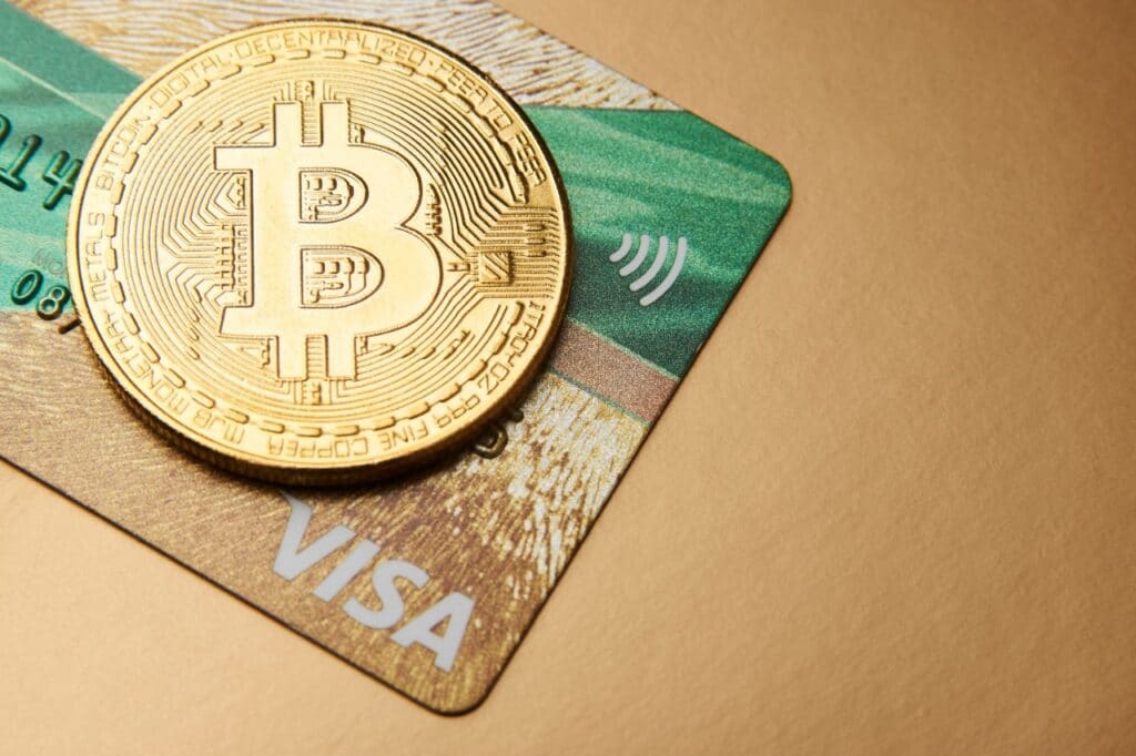 Un bitcoin y una tarjeta Visa.