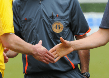 Arbitro de fúbol usa pin de Bitcoin.