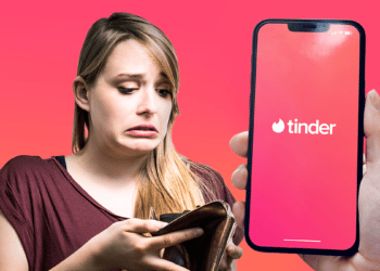 Persona preocupada por tener la billetera vacía y teléfono con logo de Tinder.