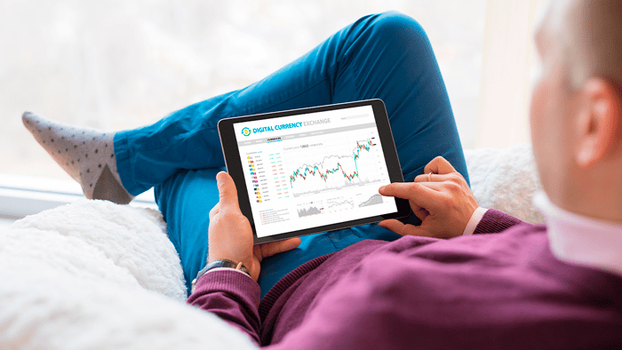 Trader with tablet looking at charts.