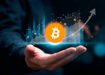 Trader sosteniendo tabla de gráfico ascendete con bitcoin.