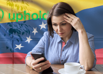 Mujer preocupada con su celular acompañada de la bandera de Venezuela y el logo de Uphold.