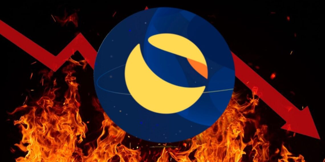 Logo del cripto LUNA sobre fuego y una flecha roja fracturada descendiente detrás