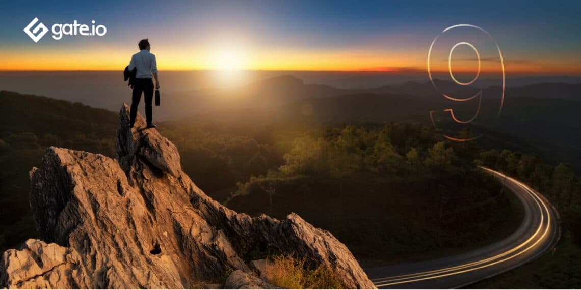 Hombre de negocios con una chaqueta de traje informal de pie sosteniendo una maletin de negocios en la cima de la montaña mirando el amanecer.