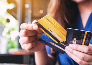 Una mujer sosteniendo varias tarjetas de crédito en sus manos.