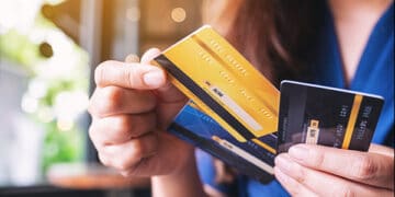 Una mujer sosteniendo varias tarjetas de crédito en sus manos.