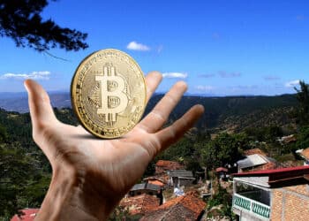 Santa Lucía, Honduras, y mano con Bitcoin.