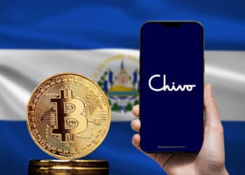 Bitcoin y un celular con la aplicación de Chivo wallet junto a la bandera de El Salvador.