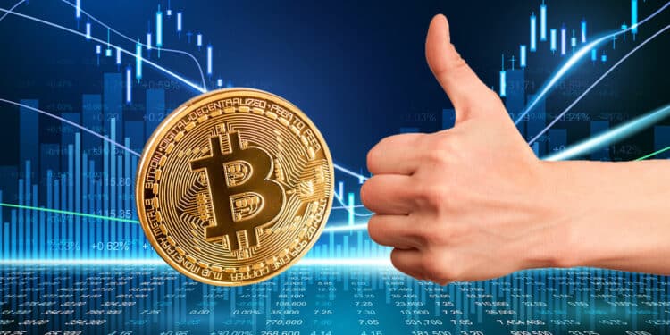 mano con pulgar arriba junto a moneda de bitcoin sobre superficie digital con gráfico de precio en el fondo