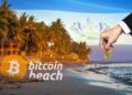 mano depositando moneda de bitcoin en playa con logo de Bitcoin Beach y bandera de El Salvador en el fondo