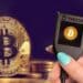 Trezor junto a monedas de Bitcoin.