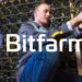 hombre acomoa equipos de minería de criptomonedas con logo de Bitfarms