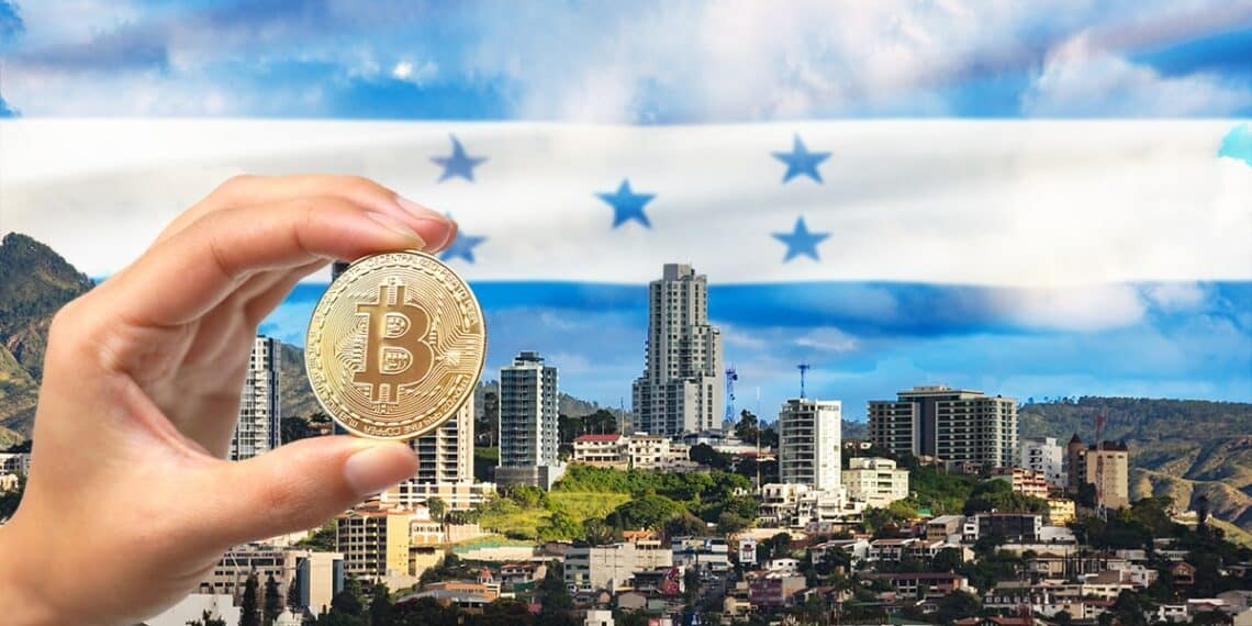 mano sostiene moneda de bitcoin en frente de ciudad con bandera de Honduras en el fondo